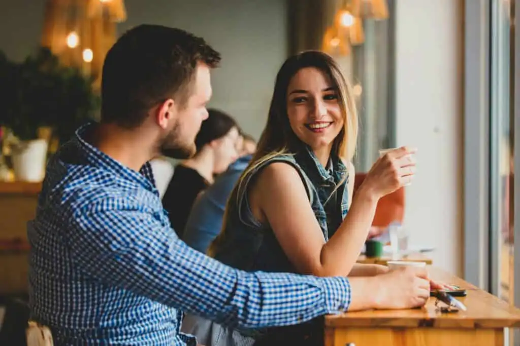 couple sitting at a table in a cafe and drinking coffee